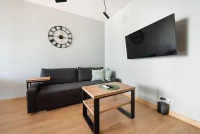Telewizja i/lub zestaw kina domowego w obiekcie Wola Skwer Happy Apartment by BookingHost