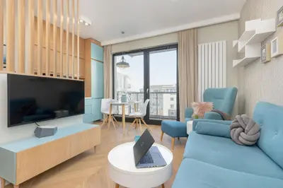 Telewizja i/lub zestaw kina domowego w obiekcie Bright Blue Apartment with Balcony, Parking and Air Conditioning in Warsaw by Noclegi Renters