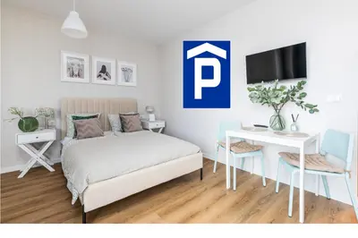 Łóżko lub łóżka w pokoju w obiekcie SuperApart Wileńska Studio z parkingiem