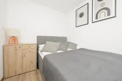 Łóżko lub łóżka w pokoju w obiekcie Elegant Grey Apartment Wspólna Śródmieście in Warsaw by Noclegi Renters