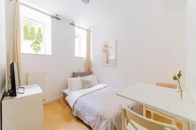 Łóżko lub łóżka w pokoju w obiekcie Jasna i funkcjonalna kawalerka - Centrum