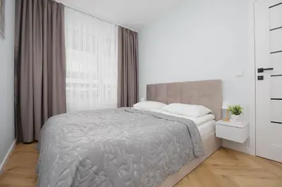 Łóżko lub łóżka w pokoju w obiekcie Beige Apartment in Warsaw with Parking and Air Conditioned Living Room by Noclegi Renters