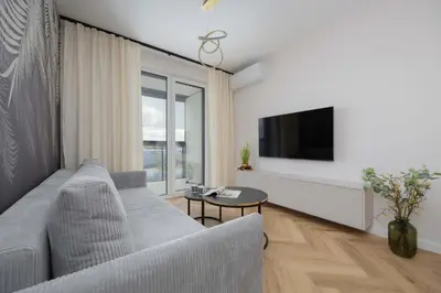 Telewizja i/lub zestaw kina domowego w obiekcie Beige Apartment in Warsaw with Parking and Air Conditioned Living Room by Noclegi Renters