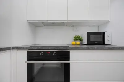 Kuchnia lub aneks kuchenny w obiekcie Bright Grey Apartment in Warsaw with Balcony by Noclegi Renters