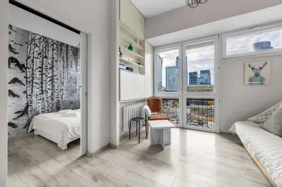 Łóżko lub łóżka w pokoju w obiekcie Żelazna Cozy Nest Apartment by BookingHost