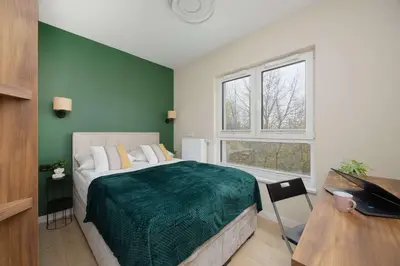 Łóżko lub łóżka w pokoju w obiekcie Green Apartment in Warsaw with Parking, Bathtub and Desk for Remote Work by Noclegi Renters