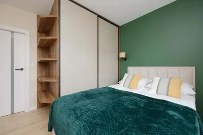 Łóżko lub łóżka w pokoju w obiekcie Green Apartment in Warsaw with Parking, Bathtub and Desk for Remote Work by Noclegi Renters
