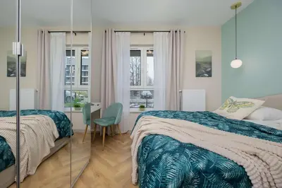 Łóżko lub łóżka w pokoju w obiekcie Pastel Apartment in Warsaw with Garden, Parking and Desk for Remote Work by Noclegi Renters