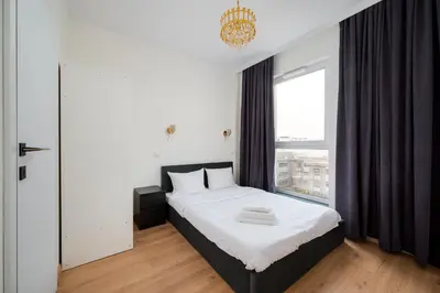 Łóżko lub łóżka w pokoju w obiekcie Ursus Spacious Apartment by BookingHost