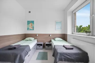Łóżko lub łóżka w pokoju w obiekcie Sport Rooms I Chodakowska Warszawa