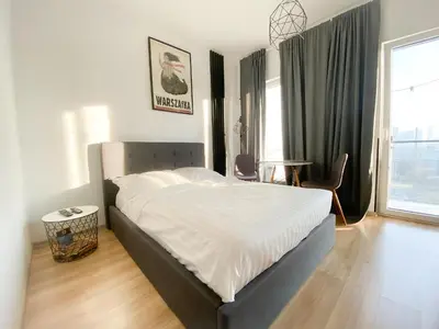 Łóżko lub łóżka w pokoju w obiekcie Bliska Wola Expo Central Apartment