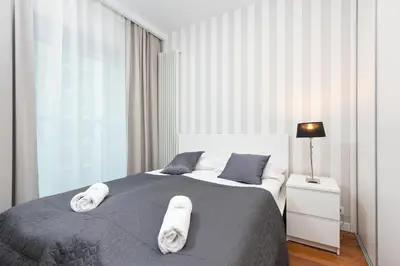 Łóżko lub łóżka w pokoju w obiekcie Royal City Center Mennica Residence by Noclegi Renters