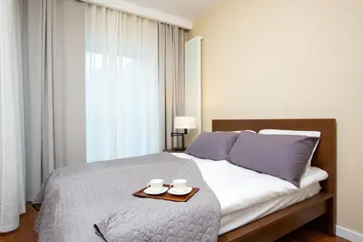 Łóżko lub łóżka w pokoju w obiekcie Royal City Center Mennica Residence by Noclegi Renters