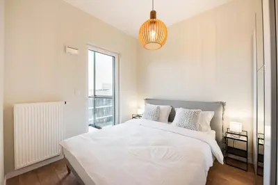 Łóżko lub łóżka w pokoju w obiekcie Wola Lush Apartment by BookingHost