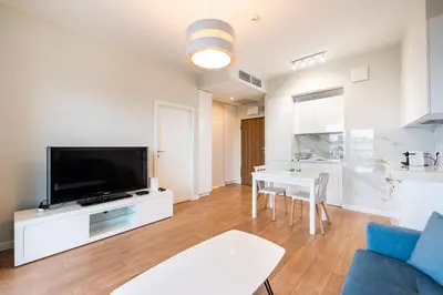 Telewizja i/lub zestaw kina domowego w obiekcie Wola Lush Apartment by BookingHost