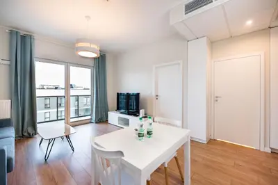 Telewizja i/lub zestaw kina domowego w obiekcie Wola Lush Apartment by BookingHost