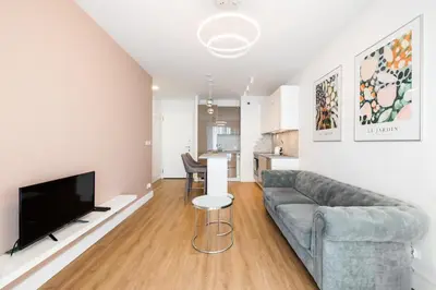 Telewizja i/lub zestaw kina domowego w obiekcie Wola Bloom Apartment by BookingHost
